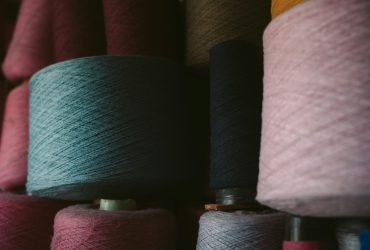 Colorful yarn spools stacked in a Oaxaca textile workshop, showcasing traditional craft materials.