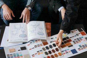 Two professionals choosing color swatches and bag designs for a fashion project.